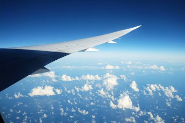 Gökyüzü ve öğle vakti beyaz bulutlu uçak penceresinden bak