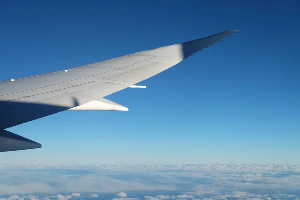 Vista desde la ventana del avión con cielo y nubes blancas al mediodía — Foto de Stock