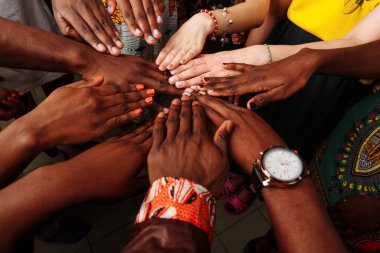 Çok uluslu Afrikalı, Latin Amerikalı ve Avrupalı insanlardan oluşan mutlu bir grubun elleri.