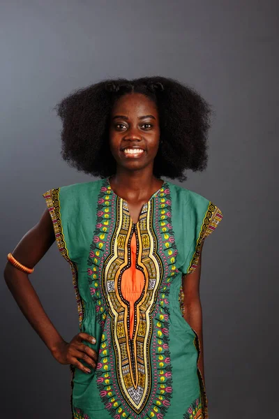 Приваблива модель африкансько-американської моди в національному одязі від конго виставляючи і посміхаючись — стокове фото