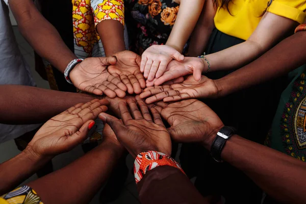 Çok uluslu Afrikalı, Latin Amerikalı ve Avrupalı insanlardan oluşan mutlu bir grubun elleri...