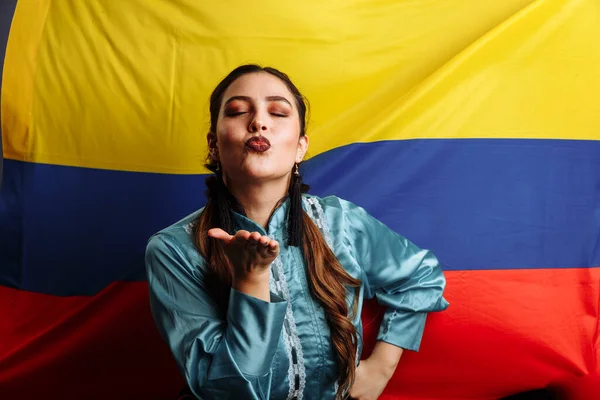 Dama colombiana besándose y bailando contra bandera nacional de Colombia — Foto de Stock