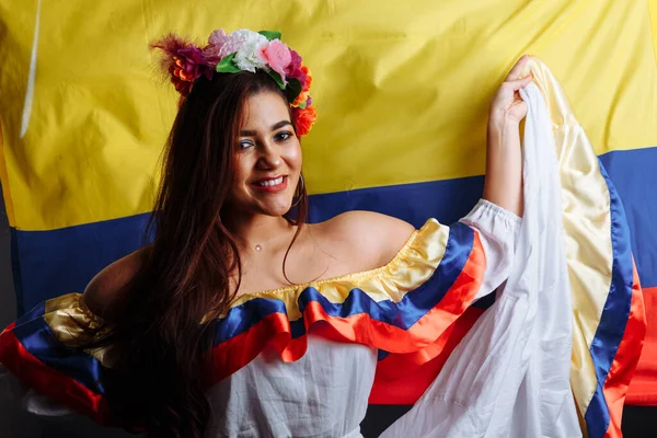 Dama colombiana sonriendo y bailando contra bandera nacional de Colombia — Foto de Stock