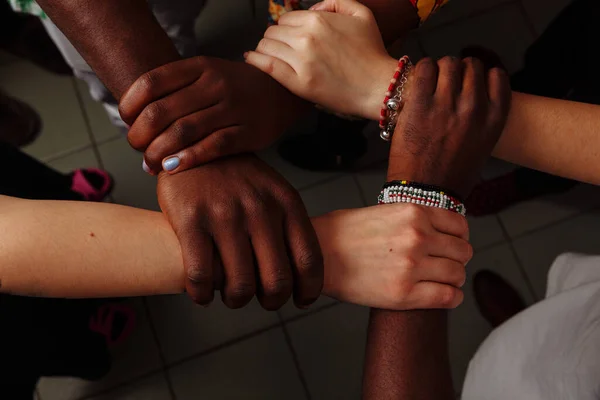 Hände des Teams einer fröhlichen Gruppe von afrikanischen Lateinamerikanern und Europäern, die im Kreis zusammenbleiben — Stockfoto