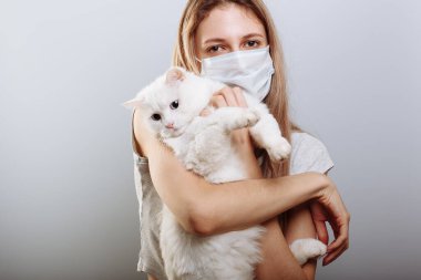 Koruyucu cerrahi maskeli seksi bayan kedi yüzlü bir maske takıyor. Çin Coronavirüs Hastalığı COVID-19 evcil hayvanlar için tehlikelidir.