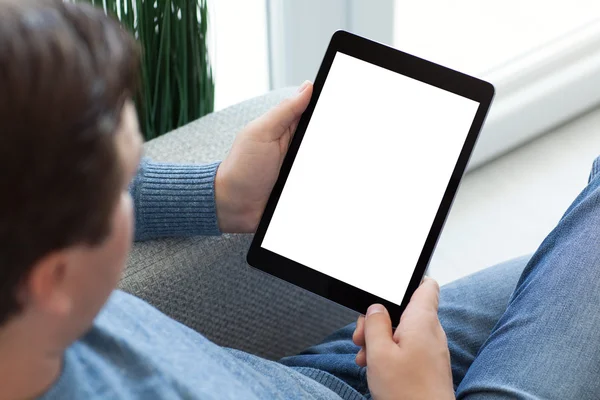Człowiek w dżinsy siedzi i trzyma na białym tle ekranu komputera typu tablet — Zdjęcie stockowe