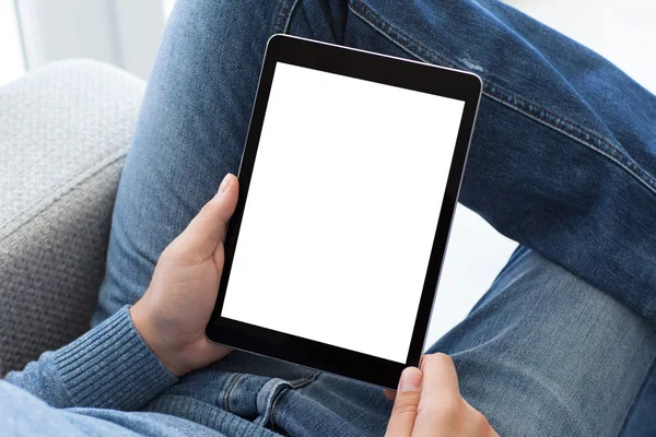 Hombre en jeans sentado sosteniendo tableta ordenador con solapa aislada —  Fotos de Stock