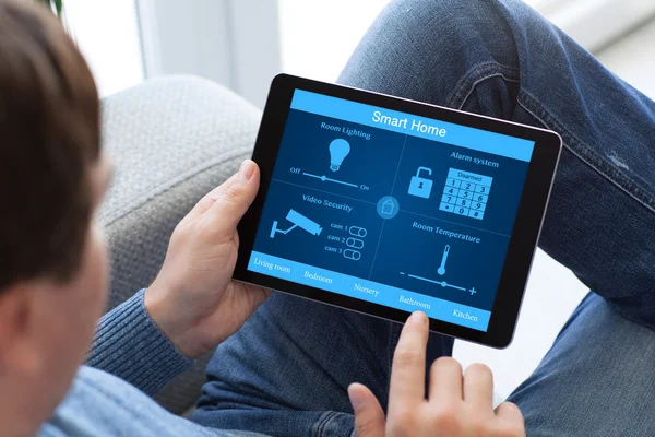 Mann in Jeans hält Tablet-Computer mit Smart Home in der Hand — Stockfoto