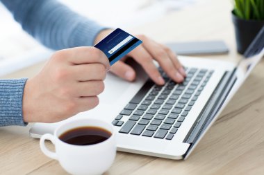 men hands with credit card on laptop keyboard and coffee clipart