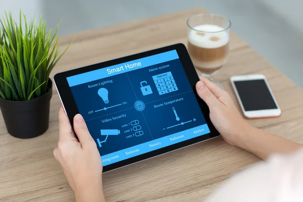 Frau hält Tablet-Computer mit Smart Home in der Nähe von Handy-Kaffee — Stockfoto