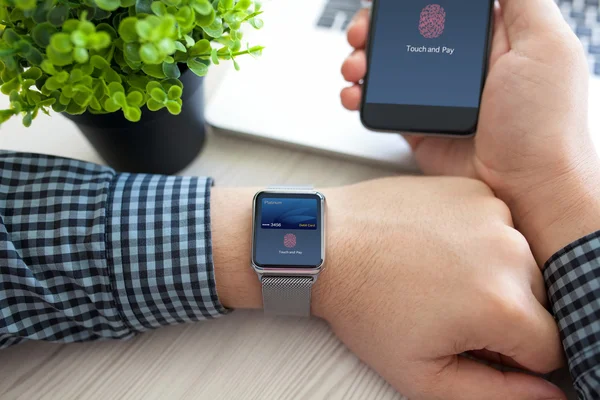 Manos de hombre sosteniendo teléfono reloj con tarjeta de débito toque de pago — Foto de Stock