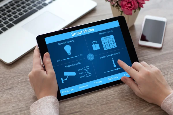 Frau hält Tablet-PC Smart Home in der Nähe von Laptop — Stockfoto