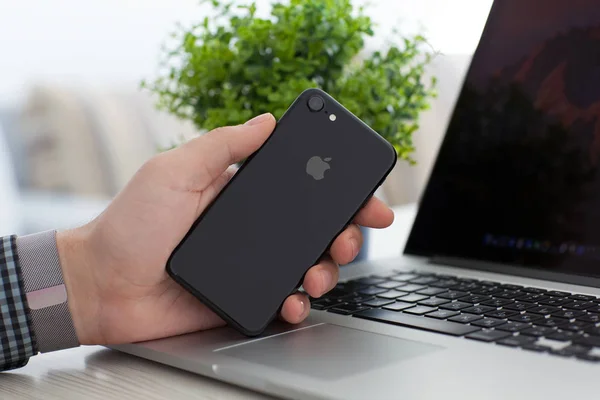 Mann Hand Apple-Uhr hält iphone 7 tiefschwarz Onyx — Stockfoto