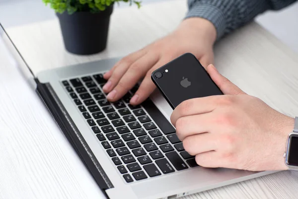 Mann Hand Apple-Uhr hält iphone 7 tiefschwarz Onyx — Stockfoto