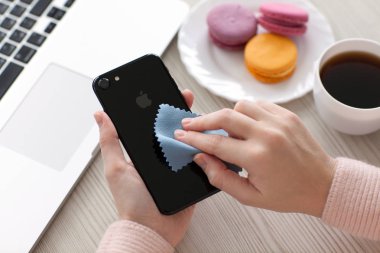 İPhone 7 tutan kadın Jet Siyah Oniks ve temizlik