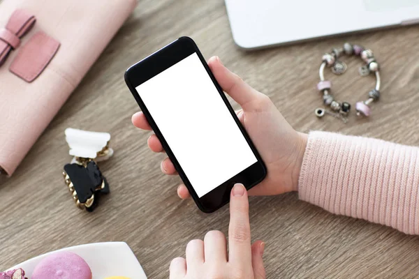 Female hand holding phone with isolated screen on table — Stock Photo, Image