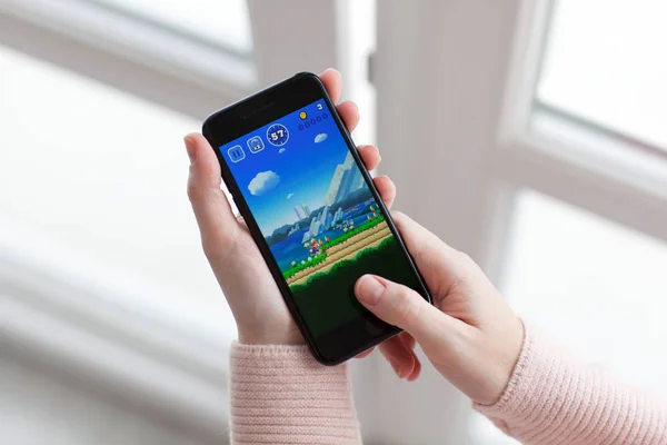 Woman holding iPhone 7 Jet Black game Super Mario Run — Stock Photo, Image