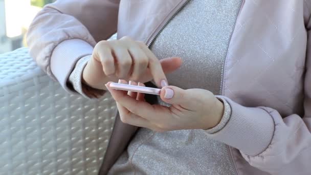 Ragazza un vestito rosa nel caffè utilizzando un telefono touch screen — Video Stock