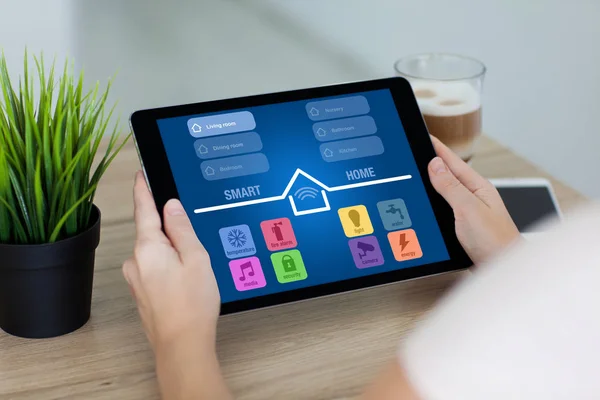 Frau hält Tablet mit App Smart Home-Bildschirm im Zimmer — Stockfoto