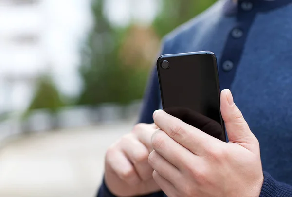 Чоловік тримає чорний дотик телефон на вулиці — стокове фото