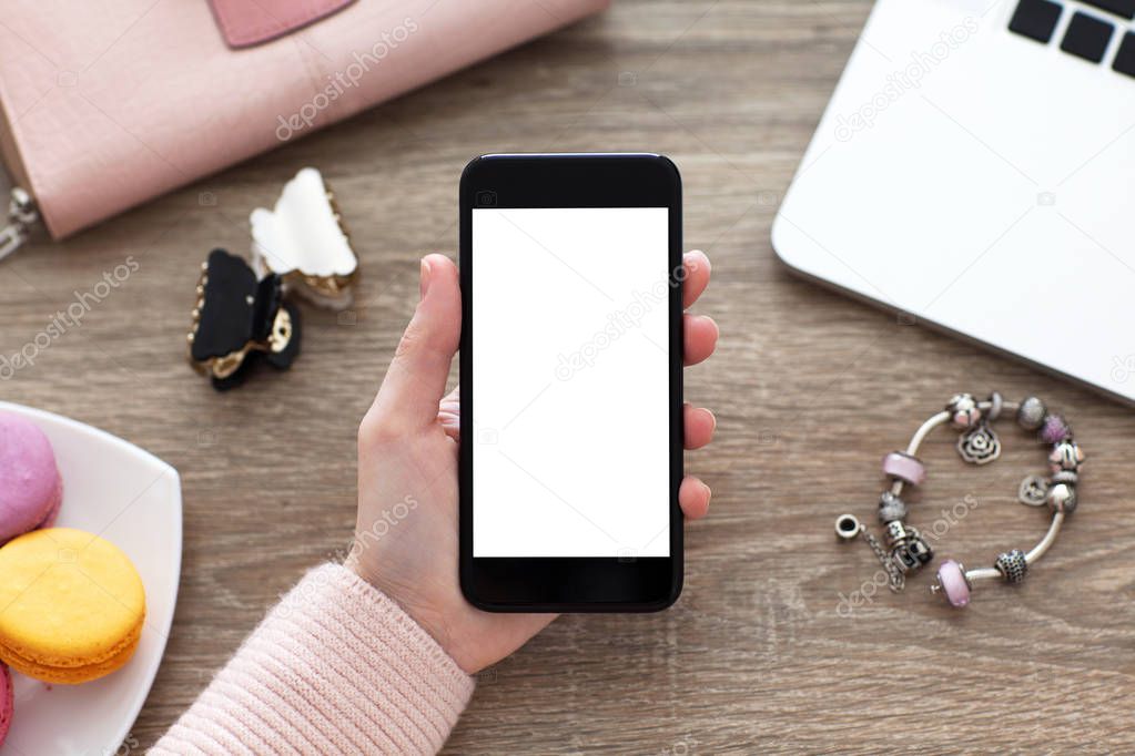 female hand holding phone isolated screen on table with jewelry