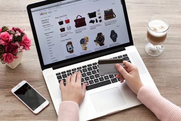 Vrouw met Macbook en de iphone Internet shopping service ebay — Stockfoto