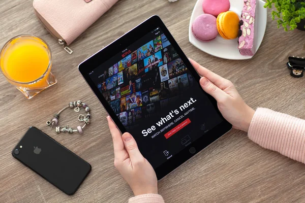 Woman holding iPad Pro Space Gray with multinational company Netflix — Stock Photo, Image