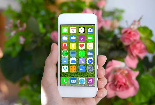 Kobieta ręka trzyma biały telefon z ekranu głównego aplikacji ikony — Zdjęcie stockowe