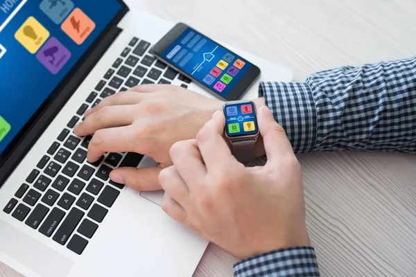 Man handen met horloge telefoon app smart home laptopscherm — Stockfoto
