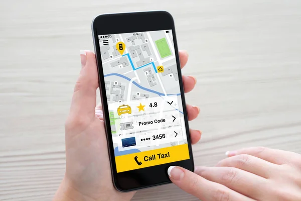 Kvinnor händer håller telefonen med programmet ringa taxi på skärmen — Stockfoto