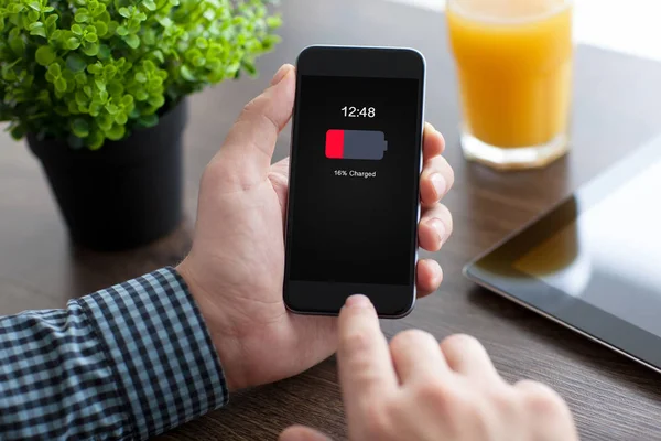 Man holding phone with low charged battery on screen — Stock Photo, Image