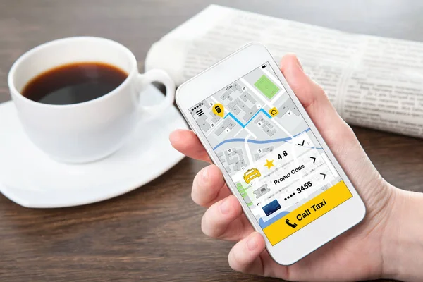 Frau hält Handy mit Anruftaxi auf dem Bildschirm — Stockfoto