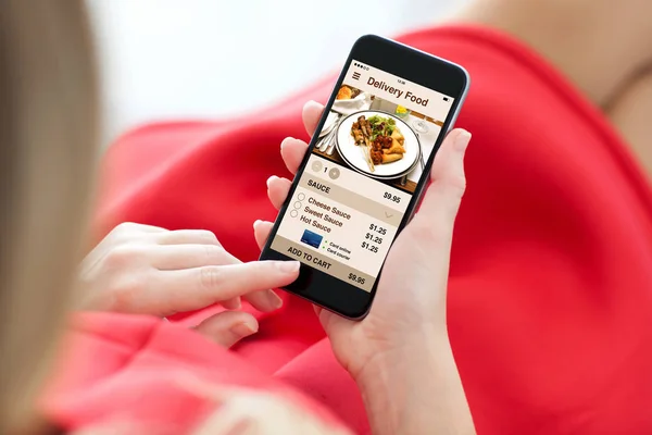 アプリ配信料理画面でタッチ携帯電話を保持している女性 — ストック写真