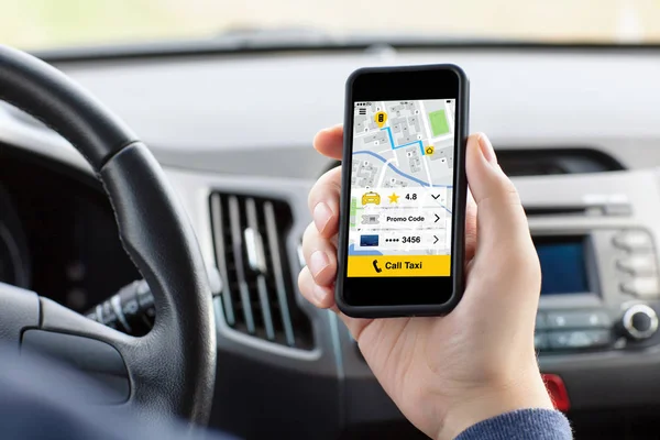 Homem mão no carro segurando telefone com aplicativo chamada táxi — Fotografia de Stock
