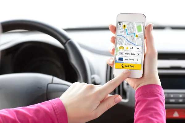 Mulher mãos no carro segurando telefone com aplicativo chamada táxi — Fotografia de Stock