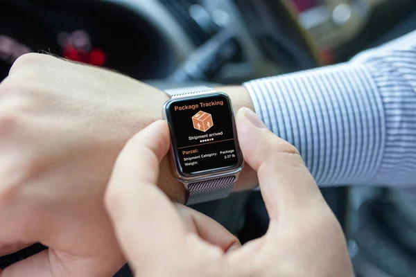 Män händer smart touch klocka med app spåra leveransen paket — Stockfoto