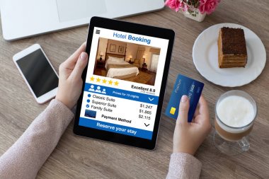 kredi kartı ve bilgisayar tablet app otel rezervasyonu tutan kadın