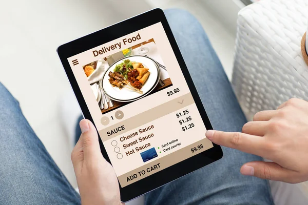 Man in jeans holding tablet computer with app delivery food — Stock Photo, Image