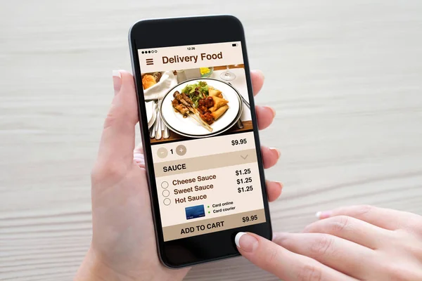 Women hands holding phone with app delivery food on screen — Stock Photo, Image