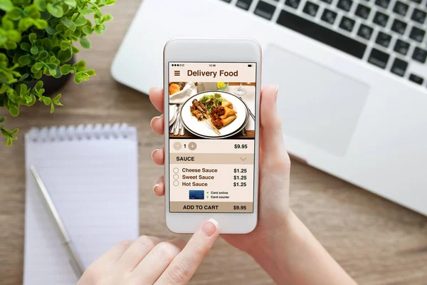 Female hand holding white phone with app delivery food screen — Stock Photo, Image