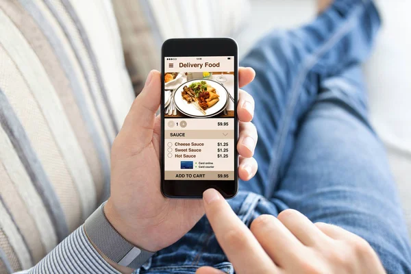 Hombre sosteniendo el teléfono táctil con comida de entrega de aplicaciones en pantalla — Foto de Stock