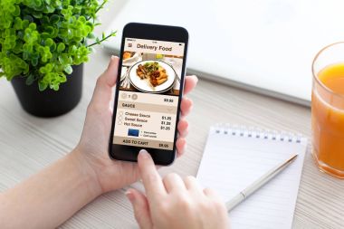 Kadın el telefon app teslim gıda ile ekran üzerinde tutarak