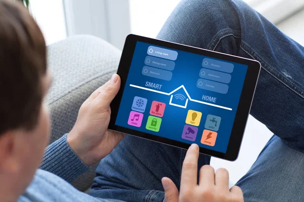 Man in spijkerbroek holding tablet met app smart home scherm — Stockfoto