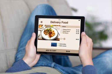 adam kanepe holding tablet ile app teslim gıda perde