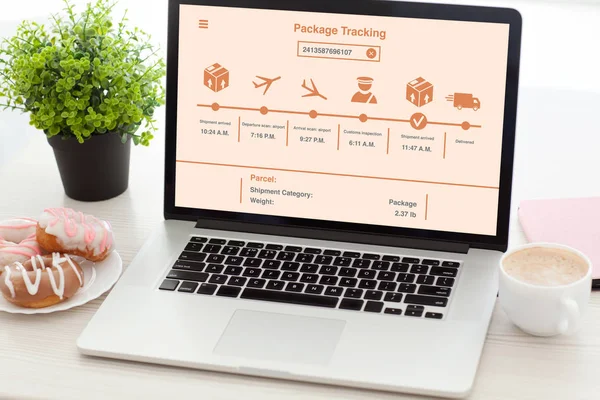 Notebook with package delivery tracking screen on  desk in offic — Stock Photo, Image