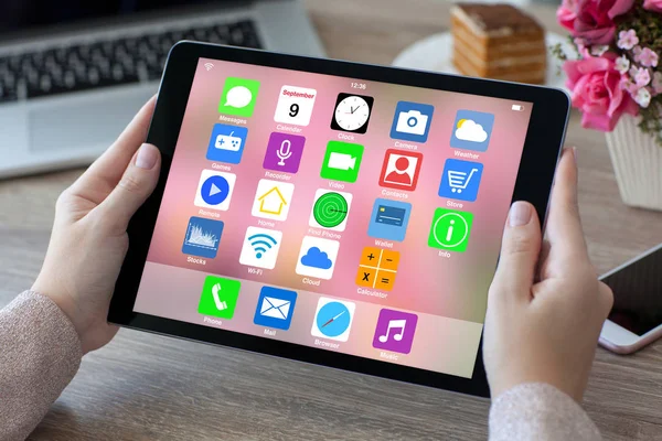 Les mains de la femme tenant tablette avec l'écran d'accueil icônes applications — Photo