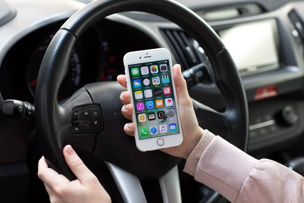 Kobieta ręce trzymając iphone 6s z ekranu głównego w samochodzie — Zdjęcie stockowe