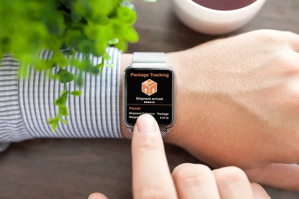 Muži rukou smart touch hodinky s app sledování doručení balíčku — Stock fotografie