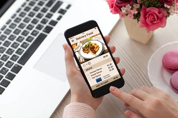 Mujeres manos sosteniendo el teléfono con comida de entrega de aplicaciones en pantalla — Foto de Stock