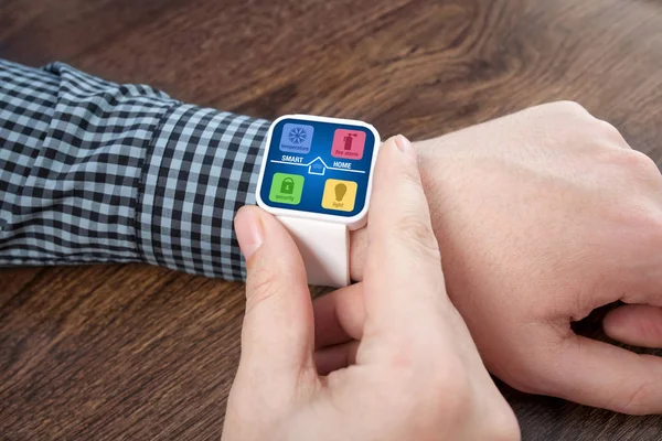 Мужские руки с белыми умными часами с приложением умный домашний экран — стоковое фото